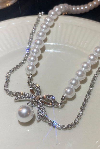 Ailsas pearl choker combines 4mm cultured pearls with a crystal-embellished bow centerpiece. The 40cm chain with 5cm extender suits most necklines.