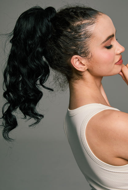 Ailsa's Wigs Hebbe ponytail extension in natural black – elegant side-back view showing soft long waves and seamless attachment.