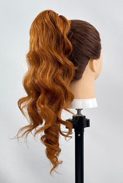 Bonnie by Ailsa’s Wigs from a right-back angle, showcasing the copper red ponytail extension with bouncy waves and a seamless wrap finish — vibrant, full-bodied, and perfect for confident styling.