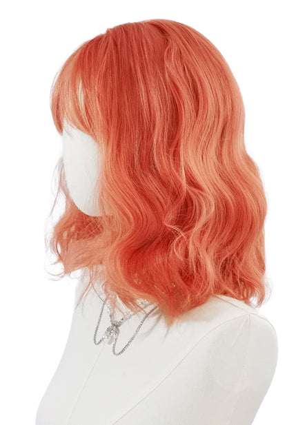 Coral peach curly wig left side view by Ailsa's Wigs, showing voluminous waves with sunset glow