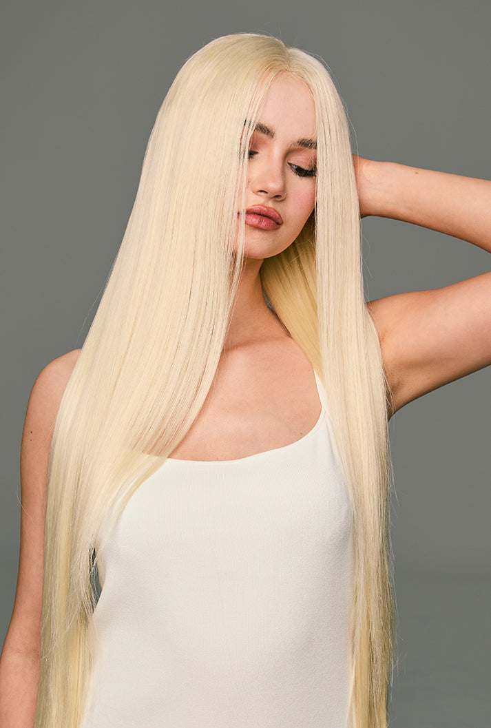 Leah by Ailsa's Wigs, model touching the back of the wig, highlighting the silky, tangle-free platinum blonde fibers and refined texture.