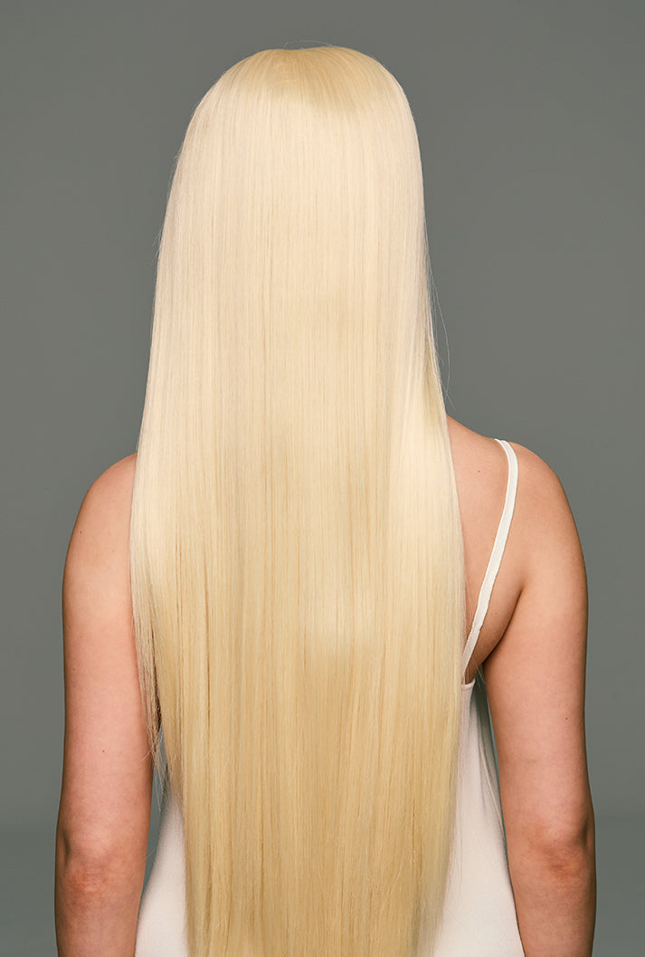 Rear view of Leah by Ailsa's Wigs, showing waterfall-like platinum blonde strands flowing naturally, exuding luxurious golden elegance.